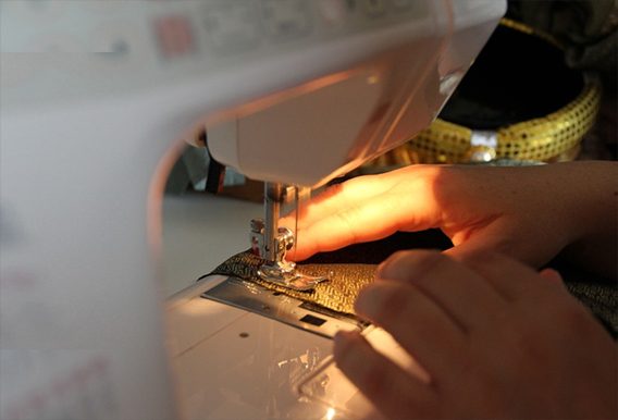 Tailor stitching suit fabric on a sewing machine